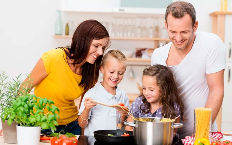 Familia feliz cocinando juntos en una placa de inducci&oacute;n